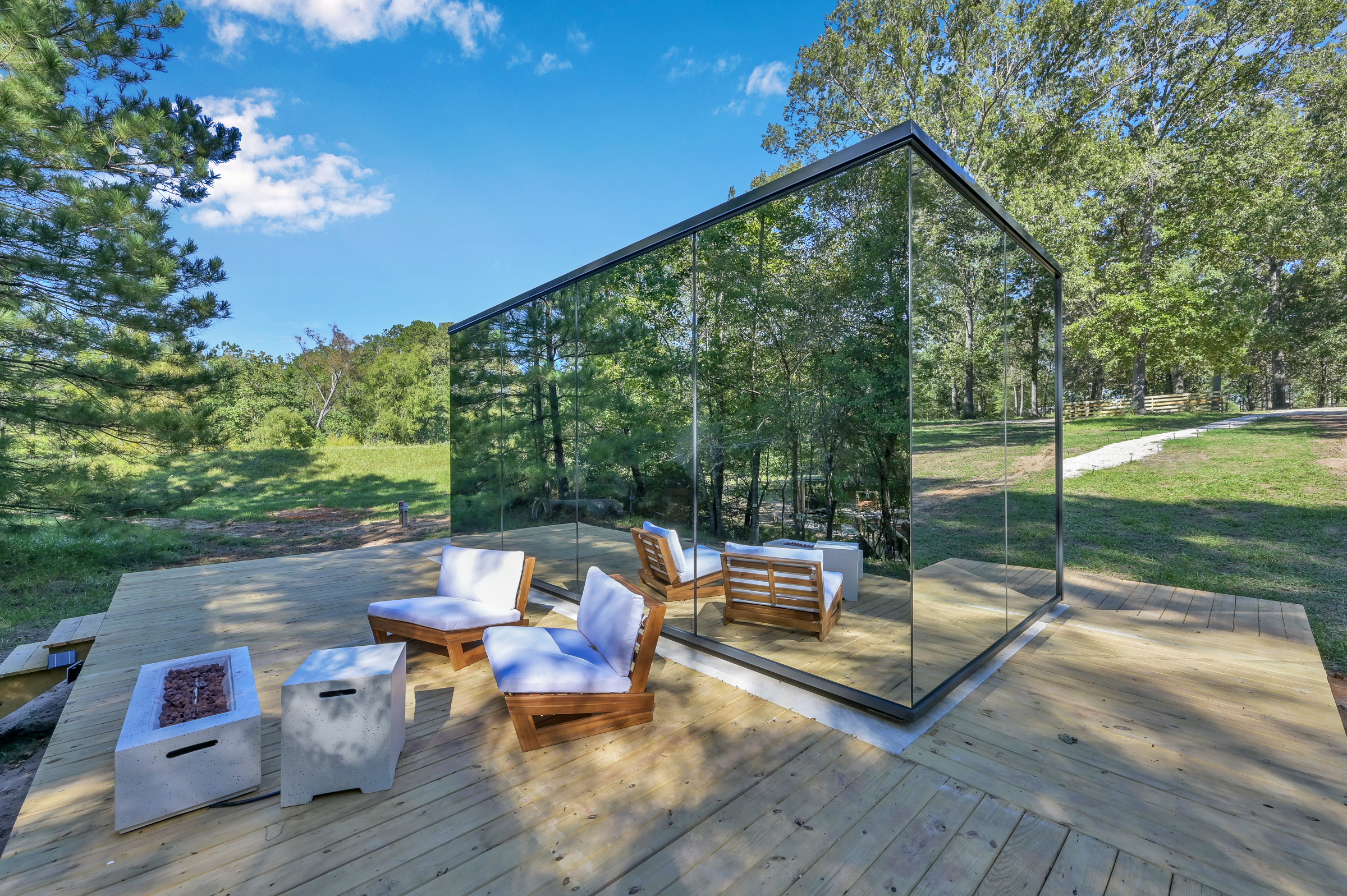 Cameron Ranch Glamping mirrored glass cabin on a cedar deck surrounded by East Texas pines